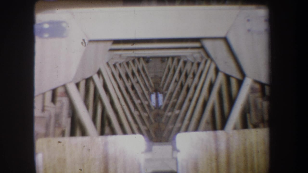 Closer view of angled wooden beams and pale scaffold supports.