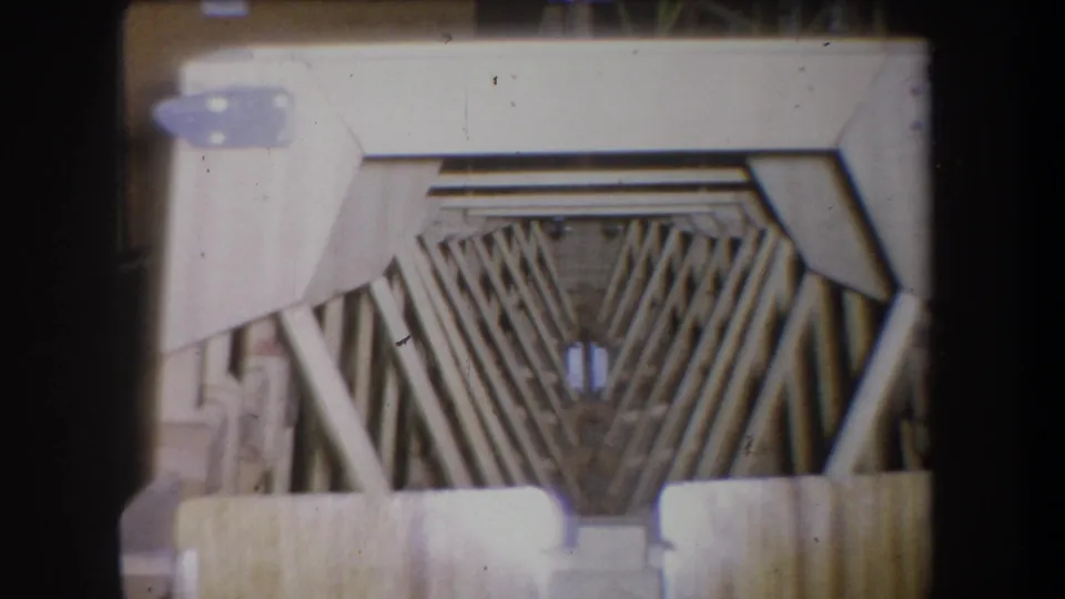Soft 8mm frame showing the scaffold opening and pale wooden supports, with no people or signage visible.