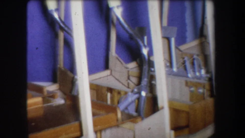 Final 1965 Yucaipa frame showing purple backing, white supports, tan wood and silver-toned fittings in a close home-movie view.
