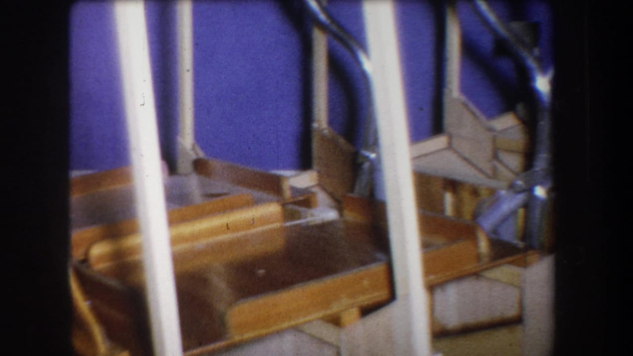 Close stair detail with white vertical rails, wooden steps, blue wall, and metal hardware.