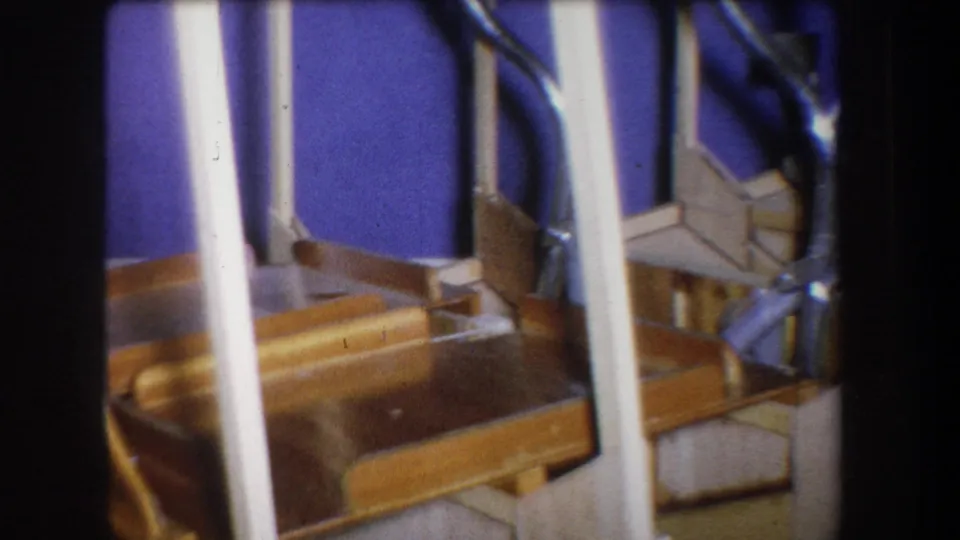 1965 Yucaipa interior detail with white stair rails crossing wooden steps and a blue wall, captured with visible 8mm color shift.