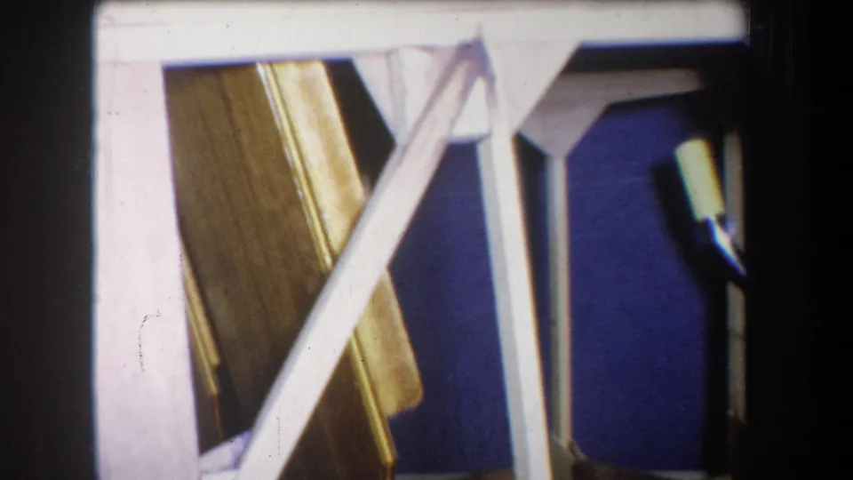 1965 Yucaipa interior frame with angled white stair supports, a varnished wooden stair side, blue wall, and visible 8mm frame edge.