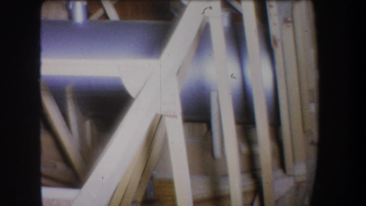 Close 8mm view from Yucaipa in 1965, with diagonal wood framing set against vertical supports and a bluish cylindrical metal element.