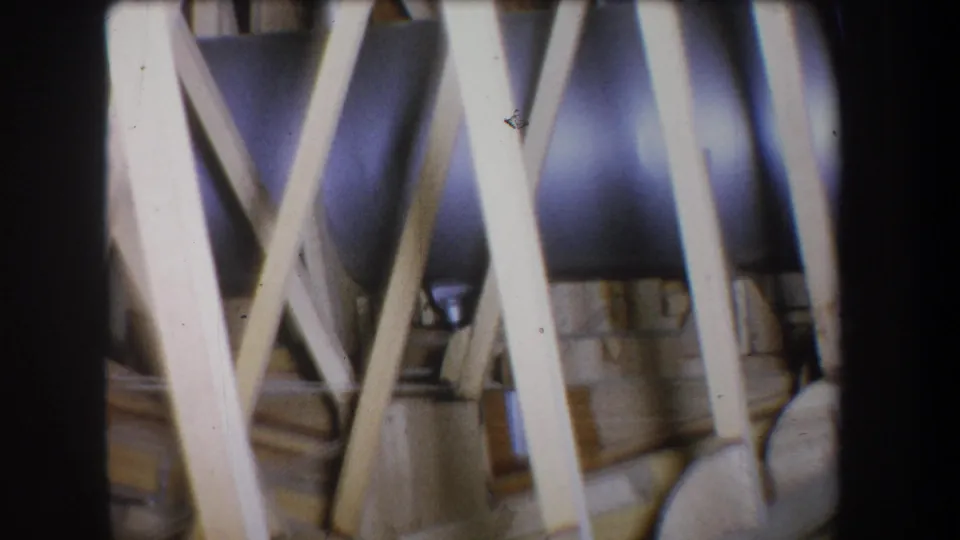 Final frame showing pale timber supports crossing over a dark metal cylinder in the 1965 Yucaipa home-movie footage.