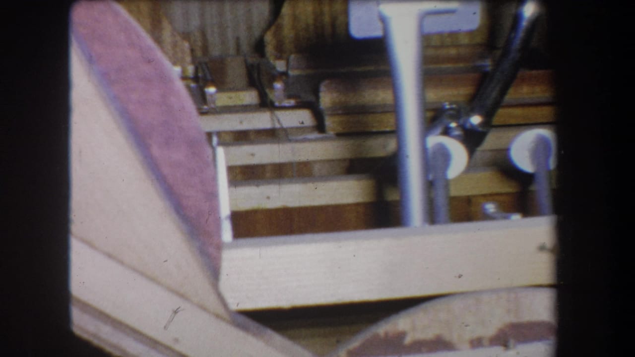 Close view of metal pedals and linkage on a wooden base, from 1965 home-movie footage associated with Yucaipa, California.