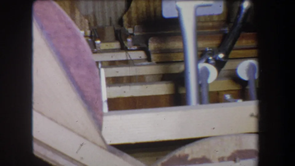 Close view of metal pedals and linkage on a wooden base, from 1965 home-movie footage associated with Yucaipa, California.