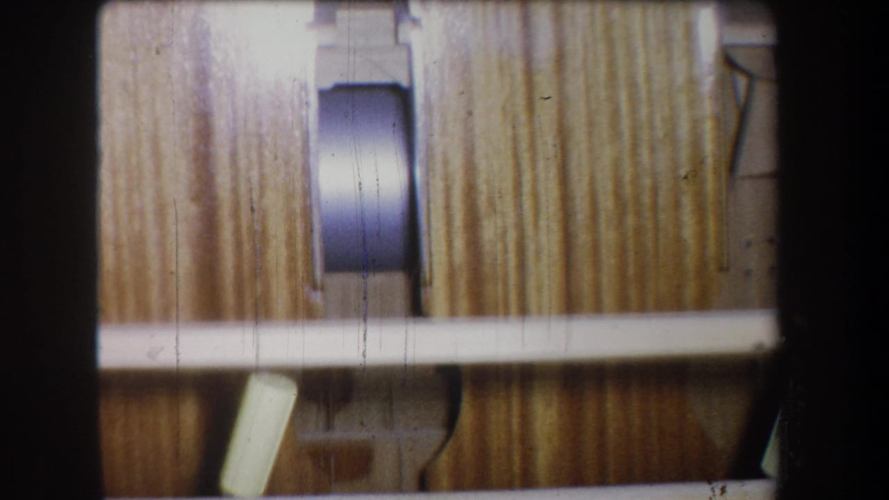 Vertical wood boards and white rails with a round dark metal or plastic fixture near the center.