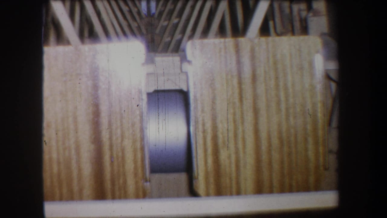 Wooden planks and a rounded cylindrical component framed by structural ribs.