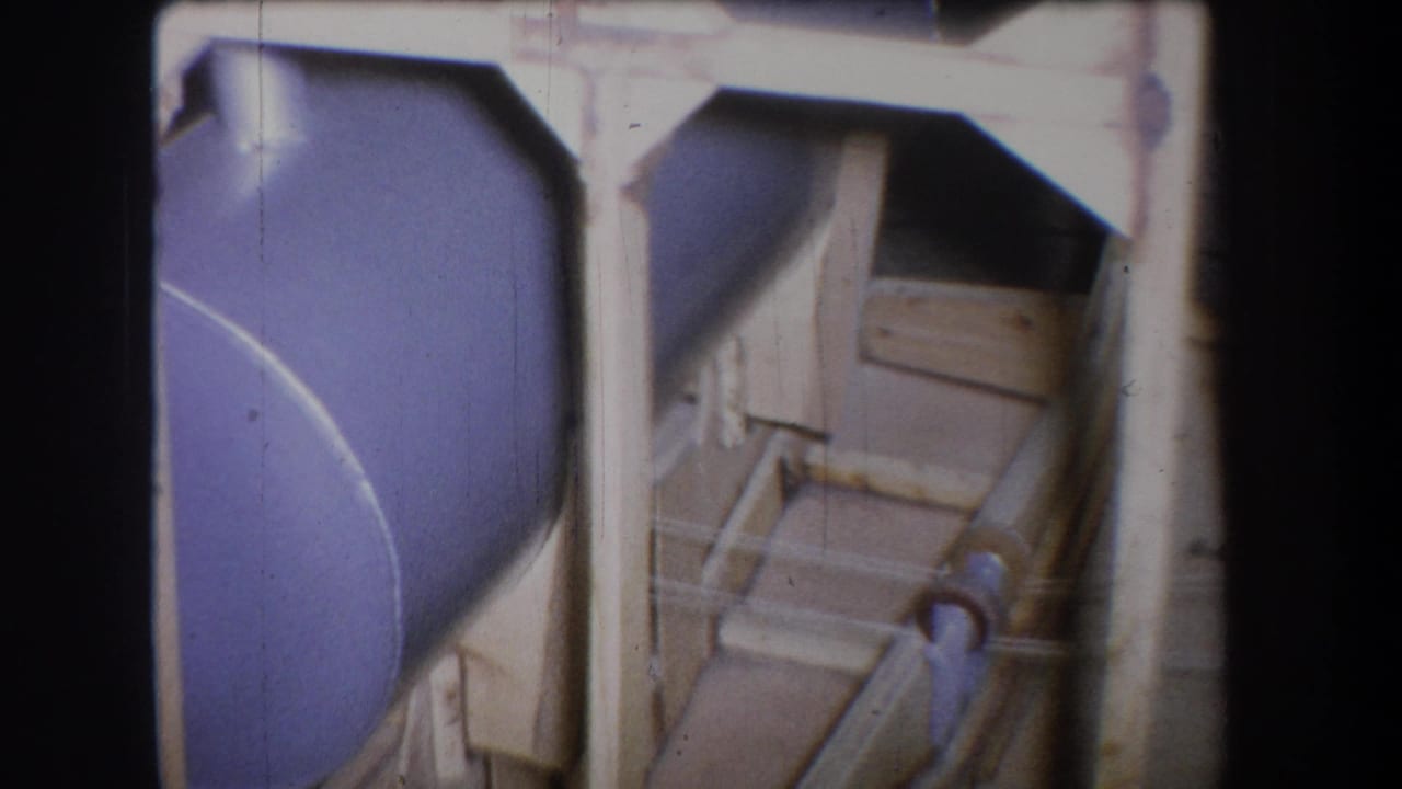 1965 Yucaipa-area 8mm frame showing a purple-painted tank, pale framing, and pipe equipment at close range.