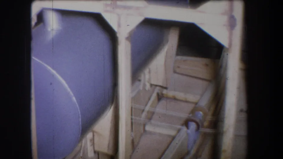 1965 Yucaipa-area 8mm frame showing a purple-painted tank, pale framing, and pipe equipment at close range.