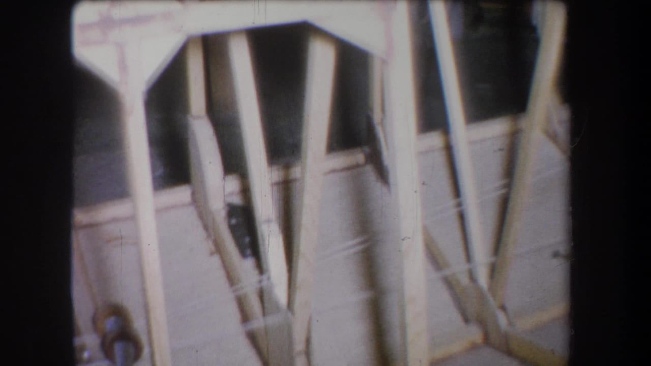 Close view of a tan wooden structure with braces, gaps, and small metal hardware.