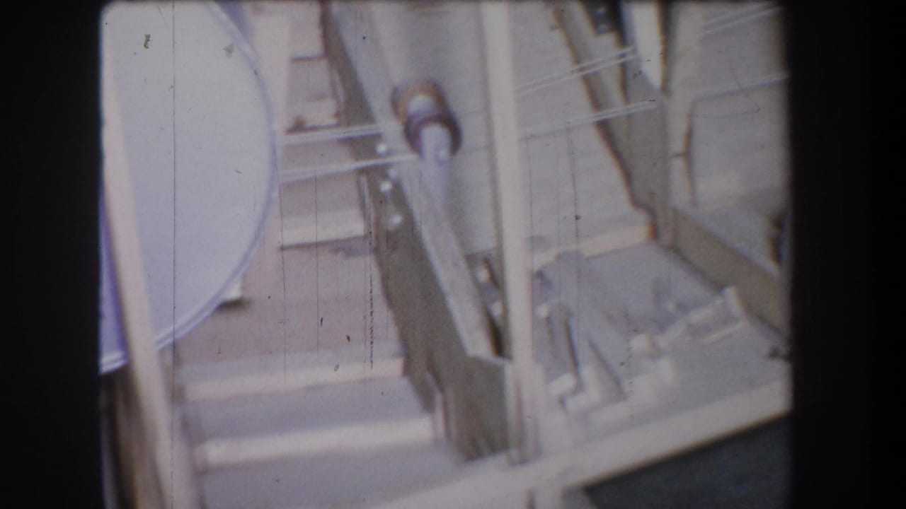 1965 Yucaipa inspection footage shows a gray cylindrical tank area with pipes, rails, and structural braces in soft 8mm focus.