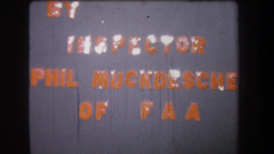 Final sampled 8mm frame of the 1965 title card, with orange FAA inspector credit text, gray background, and visible film wear.