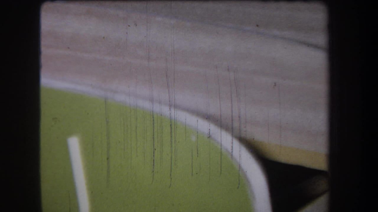 Green curved panel with a pale diagonal line and beige surface above it.