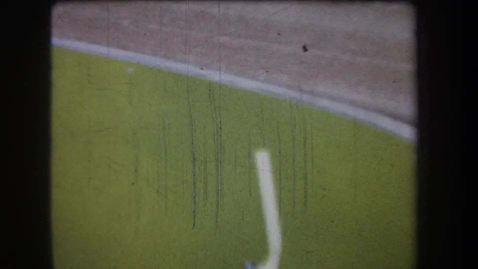 1965 8mm frame showing the green section of the structure more prominently, with a pale vertical mark and pronounced film scratches.