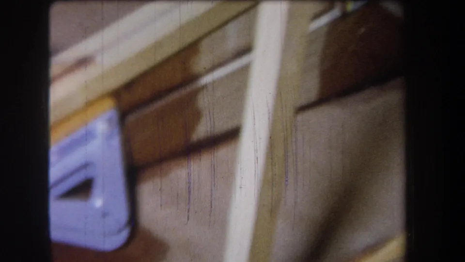 Handheld 8mm close-up from Yucaipa, California, with a partial purple bracket, wood trim, and brown boards.
