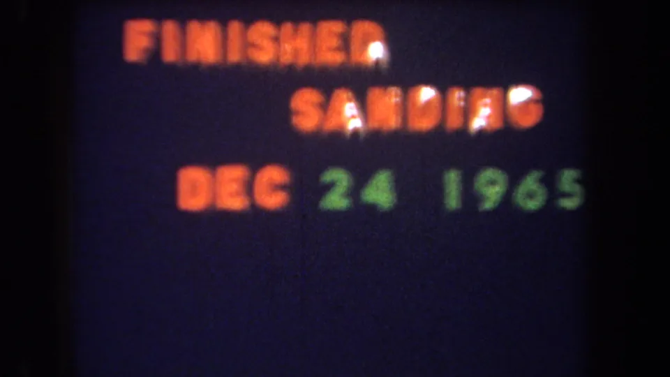 Yucaipa-area 1965 home-movie frame showing a projected title card for a finished sanding project dated December 24, 1965.