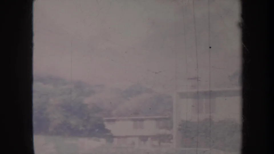 Soft 8mm Honolulu airport view showing low buildings and trees through faded color and heavy contact-sheet borders.