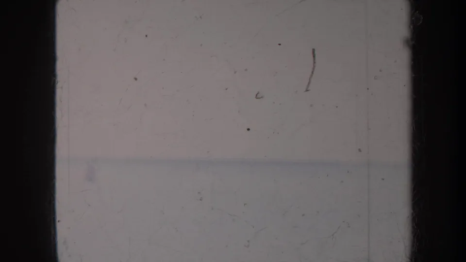 1967 Honolulu home-movie frame showing hazy ocean water and overexposed sky with dark 8mm frame edges.