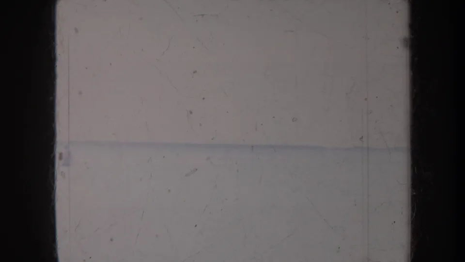1967 Honolulu 8mm frame with pale water, washed-out sky, film scratches, and dark scan borders.
