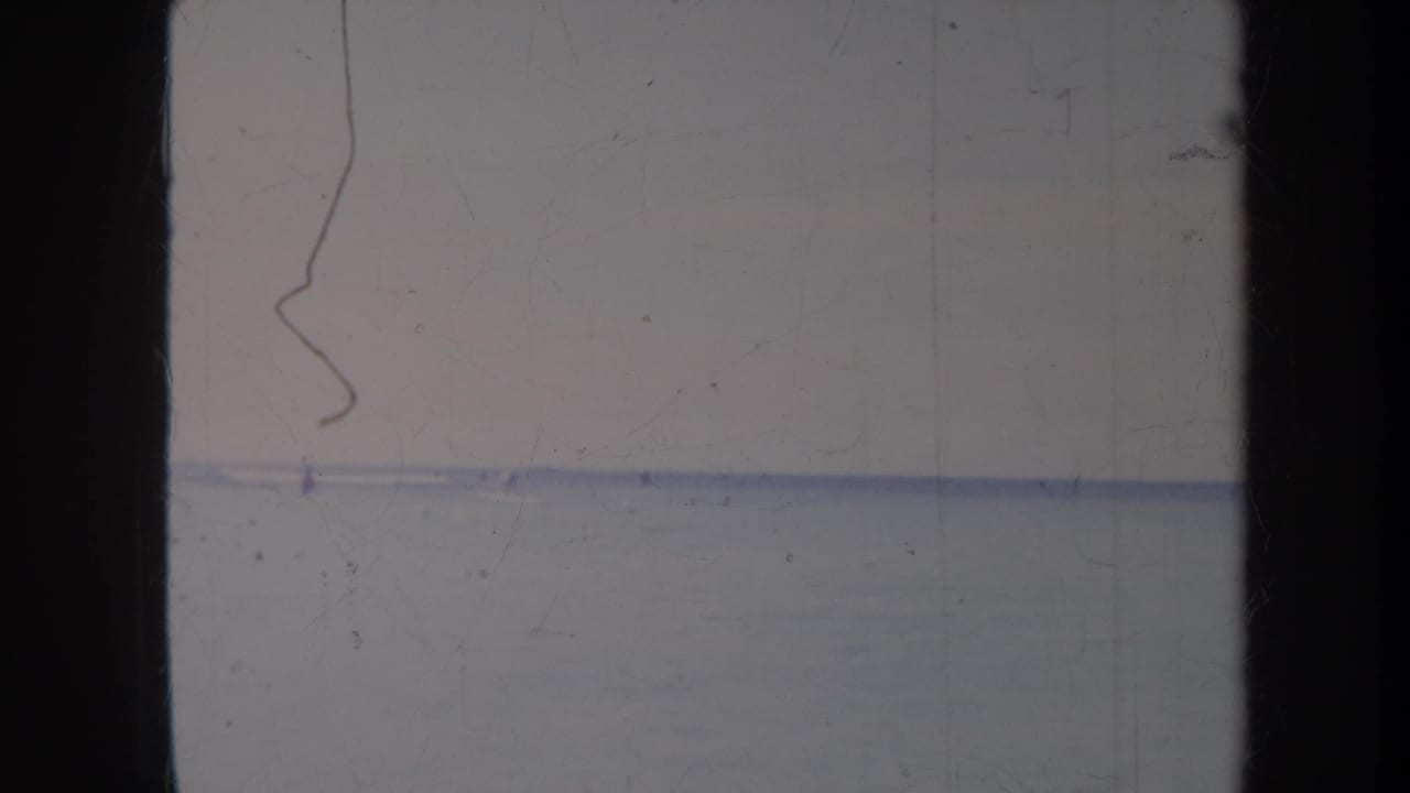 Wide ocean horizon with a small distant person in the water.