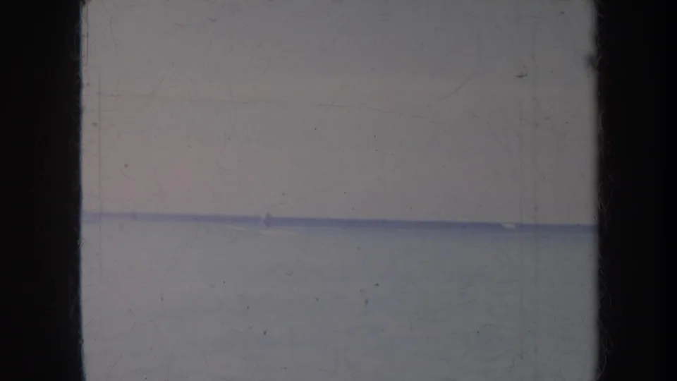 1967 Honolulu ocean frame with a faint distant figure or object near the horizon and muted 8mm color.