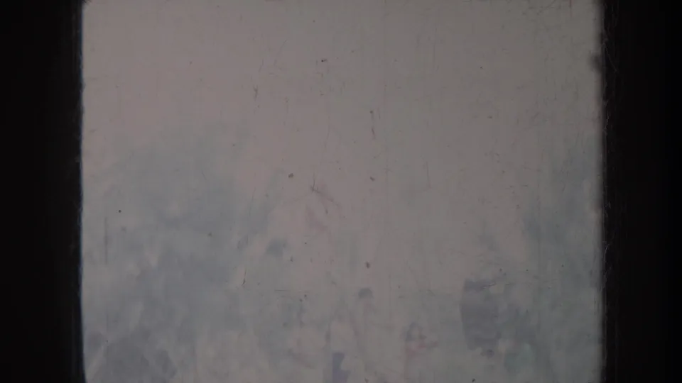 Hazy 1967 Honolulu 8mm frame divided by a dark vertical edge, with faded tones and indistinct outdoor forms.