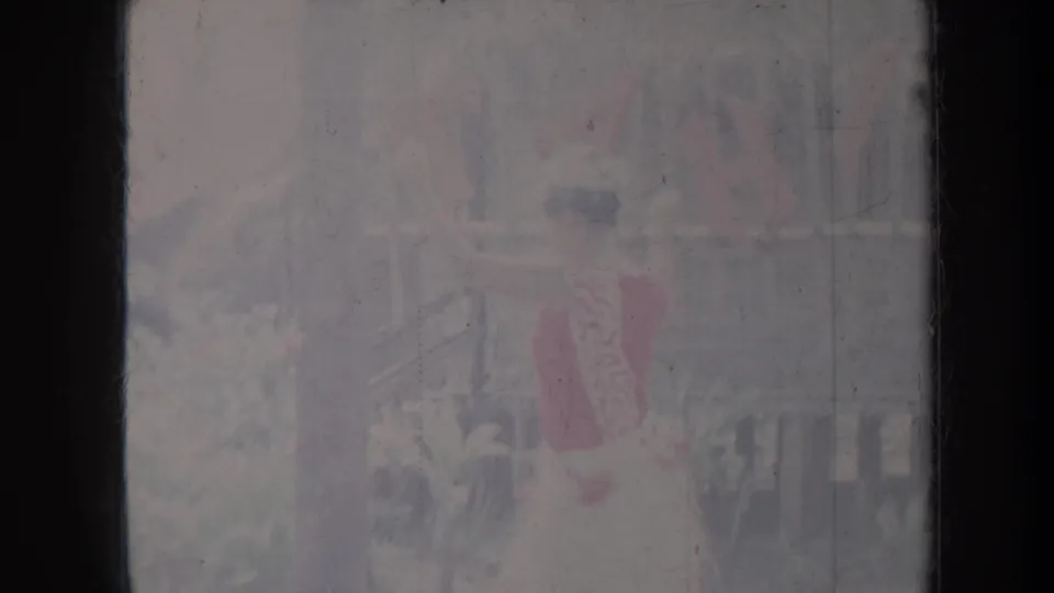 1967 Honolulu frame of a dancer in red and pale clothing, seen through soft, scratched 8mm film exposure.