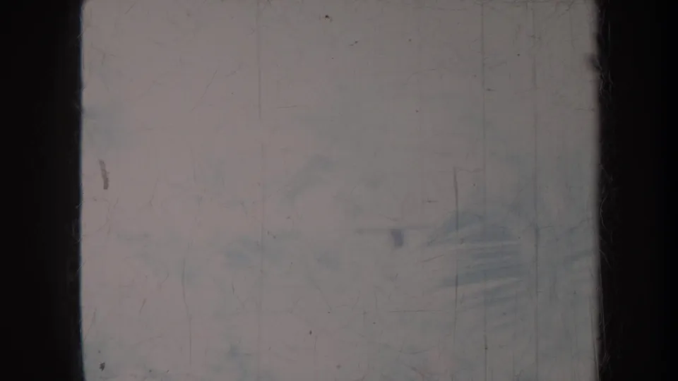 1967 Honolulu 8mm frame with dark borders, faded exposure, and faint tropical plant forms behind scratches and dust.