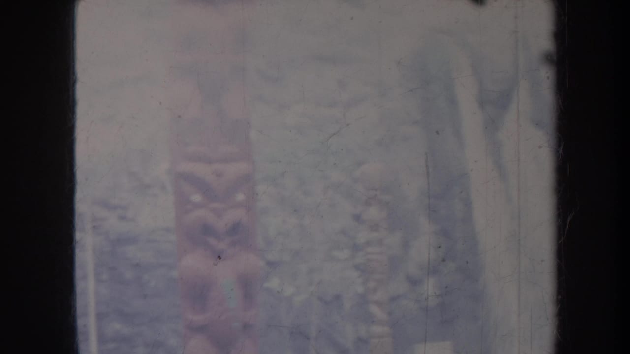 Soft, faded view of a waterfall or pale cliff surface partly obscured by dark vertical frame edges.