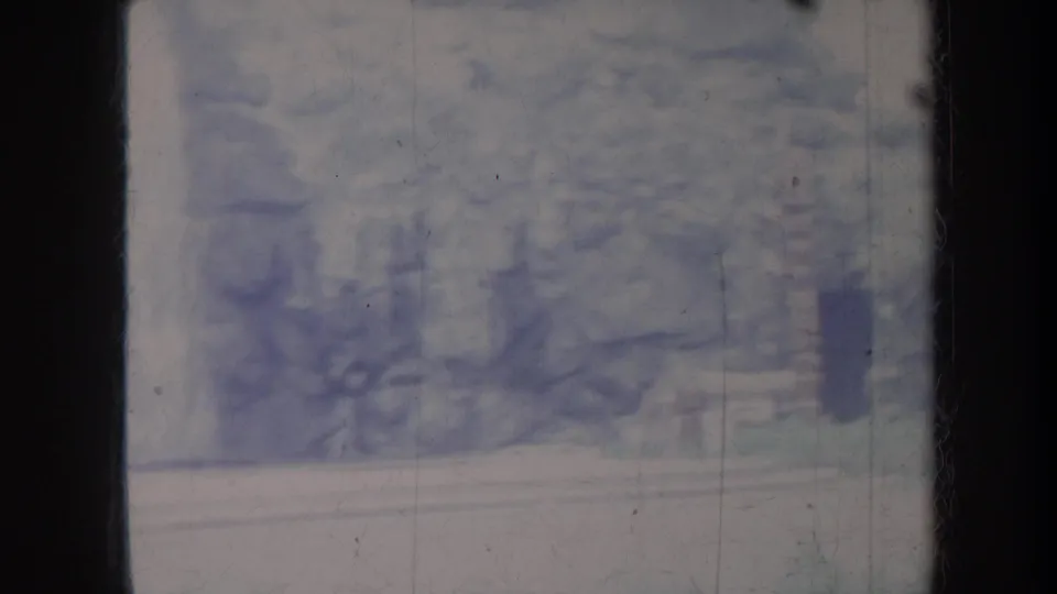 1967 Honolulu 8mm frame showing rocky cliff textures, vegetation, and a pale lower ledge at the end of the pan.