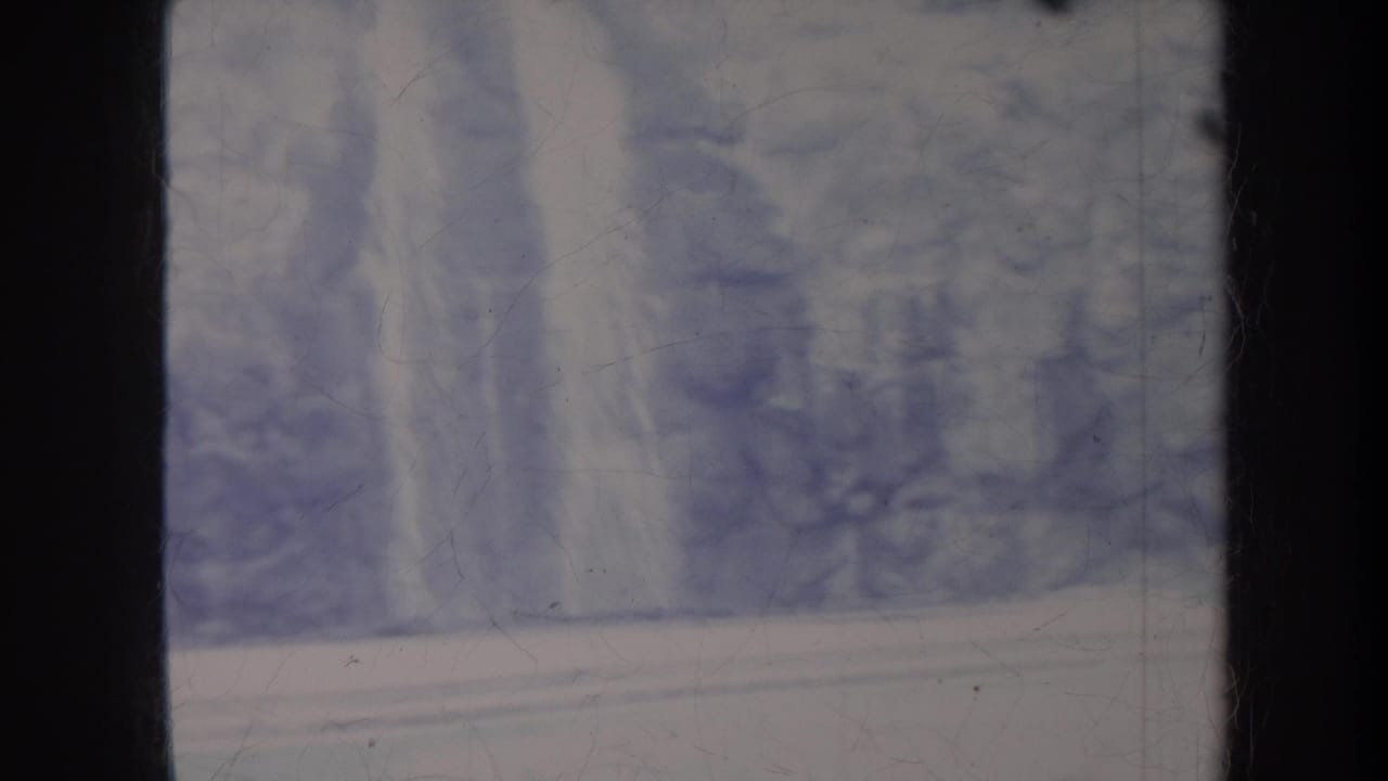 Soft view of a pale waterfall or water feature behind a low wall.