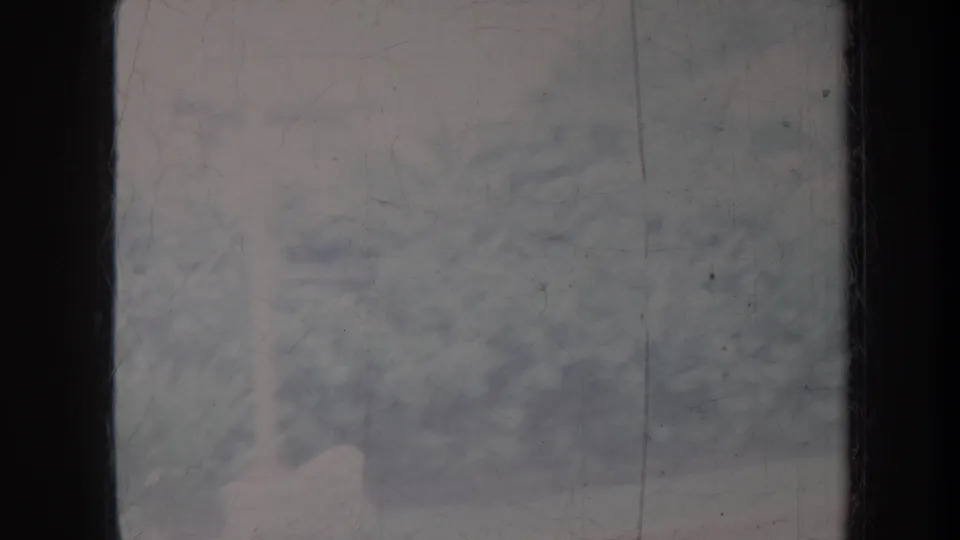 Obscured 1967 Honolulu home-movie frame with pale exterior forms behind scratched, faded glass.