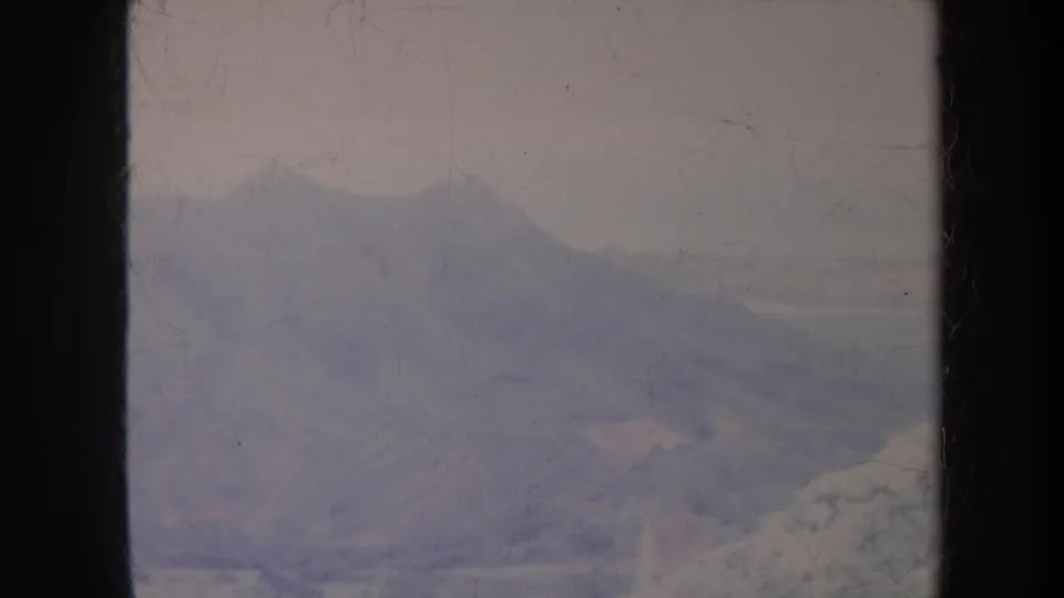 1967 Honolulu 8mm frame showing a blurred mountain slope and valley-like terrain in muted color.