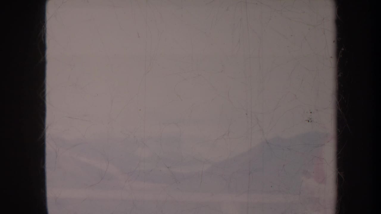 Soft view of distant hills and sky with the figure mostly out of frame.