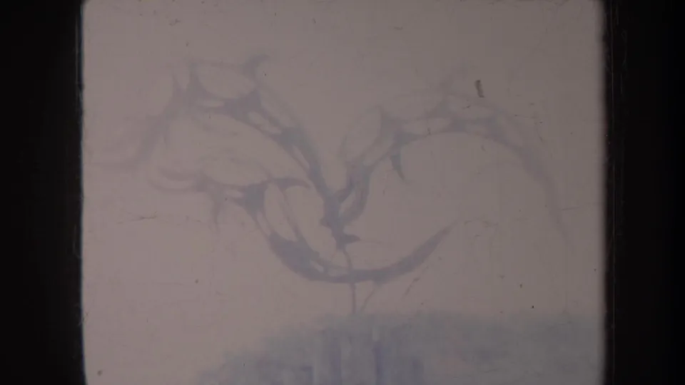 1967 Honolulu frame showing the metal sea-creature sculpture and stone wall in a softly faded visitor-shot 8mm view.