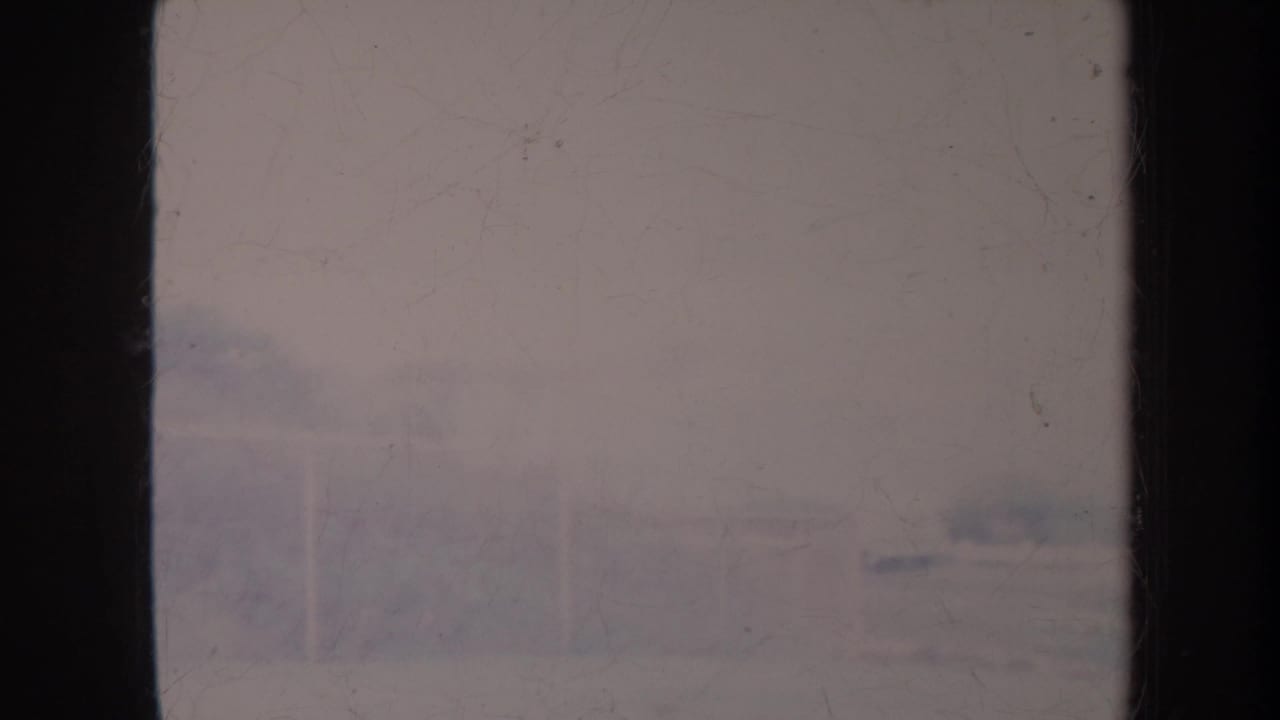Hazy overexposed water surface seen through dark film-frame edges.