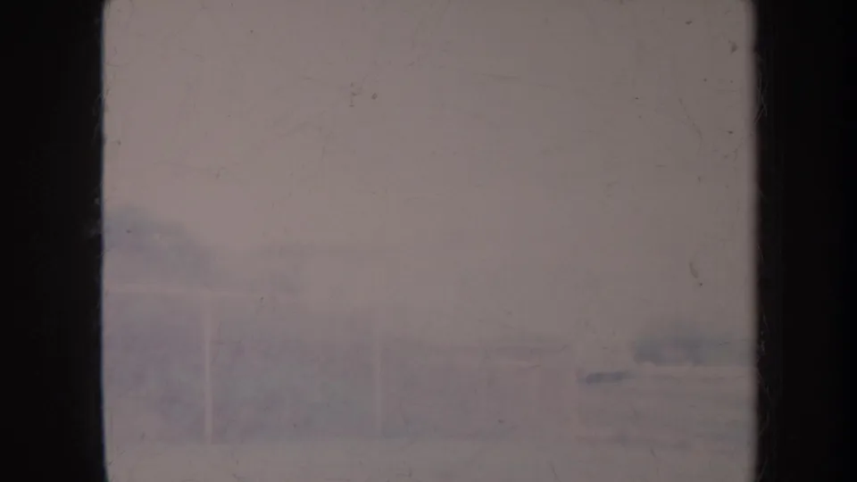 1967 Honolulu home-movie frame with a pale, hazy above-water view bordered by dark film edges and light scratches.