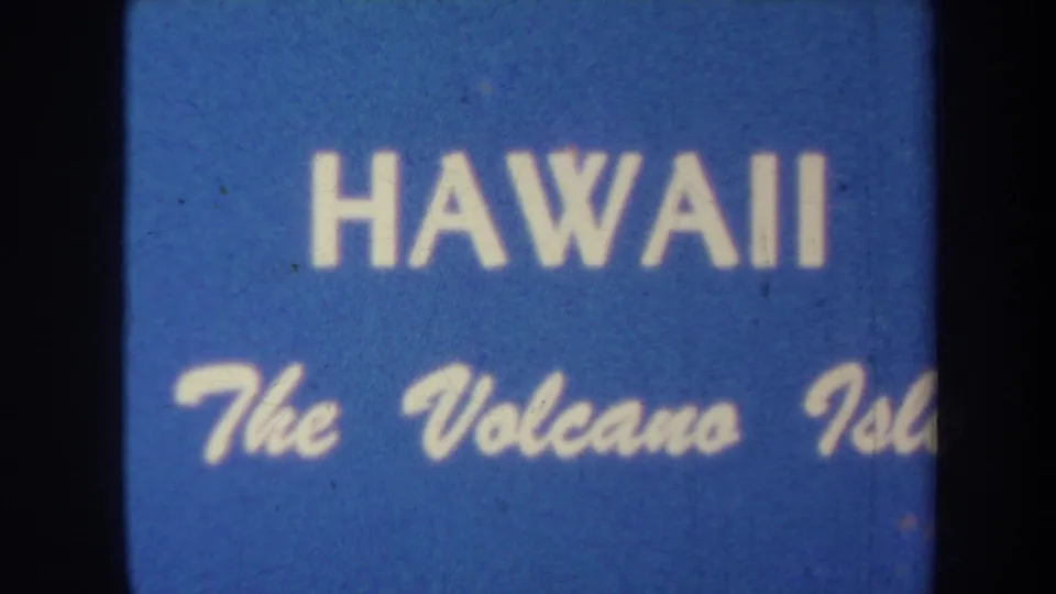 Blue 8mm title card for Hawaii, with block lettering and cursive Volcano Island subtitle visible through soft focus.