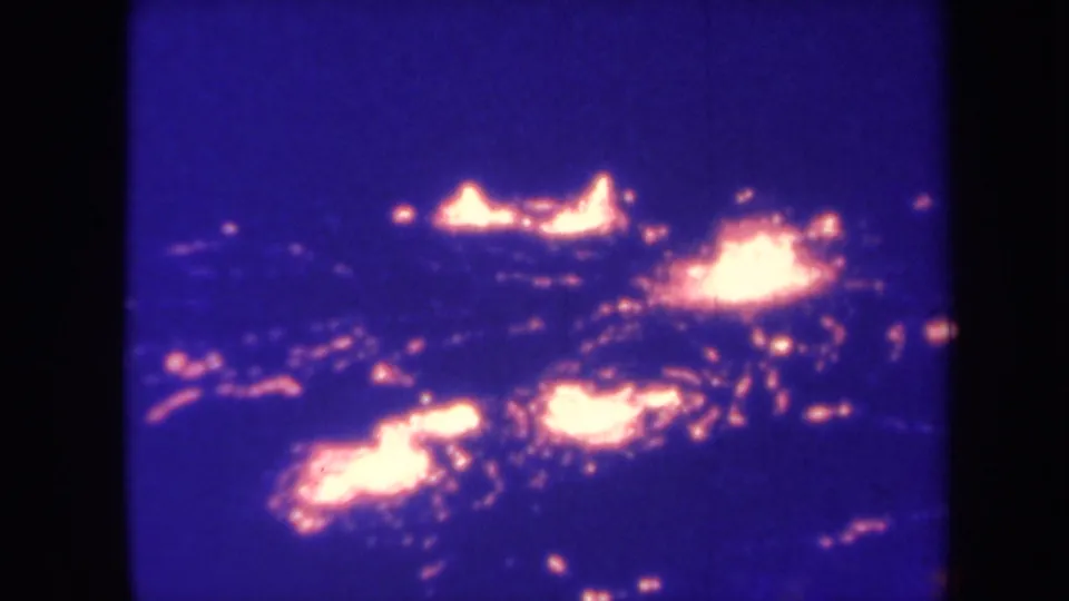 1967 Hawaii 8mm frame showing bright orange lava-like glow across dark blue volcanic ground.