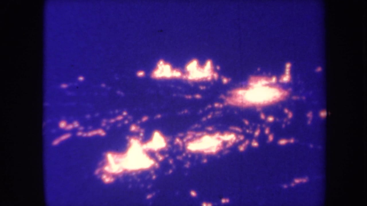 1967 Honolulu 8mm frame showing scattered bright flames and embers against a dark blue night field.