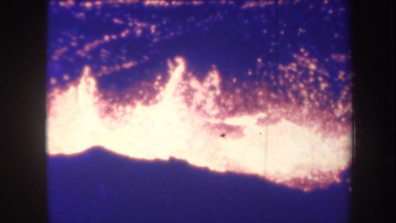 Large bright flame front spreads across a dark blue nighttime scene.