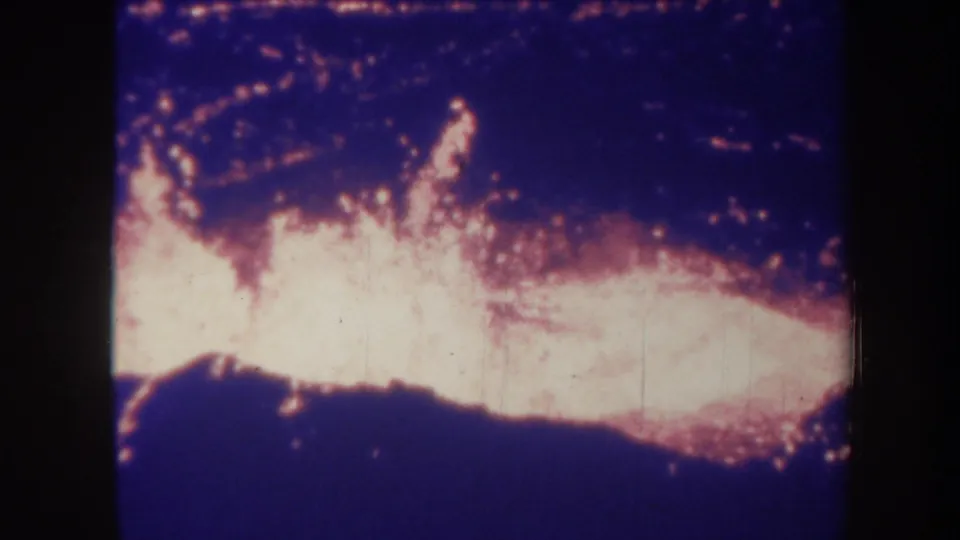 1967 Honolulu 8mm frame showing a bright horizontal fire line with dark silhouetted shapes below it.