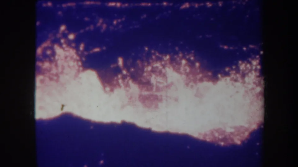 1967 Hawaii 8mm frame showing an intense overexposed lava glow below a dark blue volcanic sky.