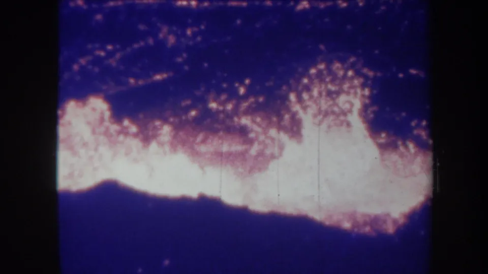 1967 Hawaii 8mm frame with a bright lava plume rising from a glowing volcanic surface at night.