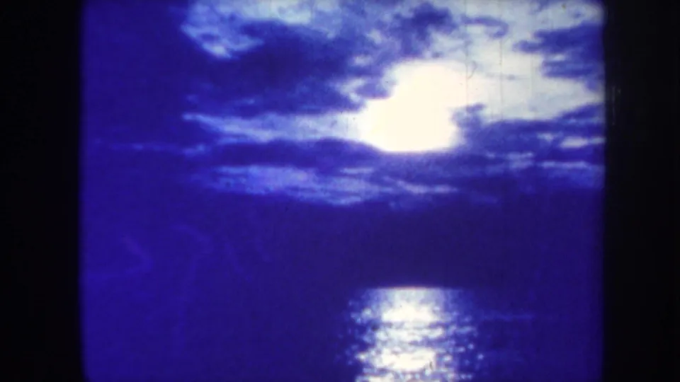 1967 Honolulu coastal home-movie frame of sun, clouds, and reflected light on the ocean.