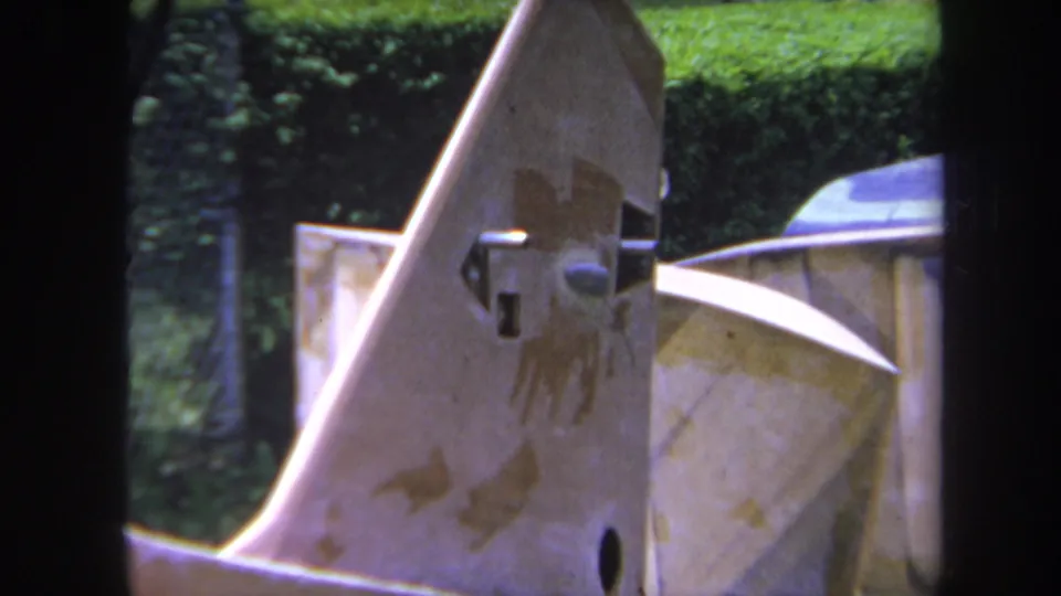 1969 8mm close-up from Volmer, Yucaipa showing an angled machinery plate with rust marks, bolts, and soft green background.