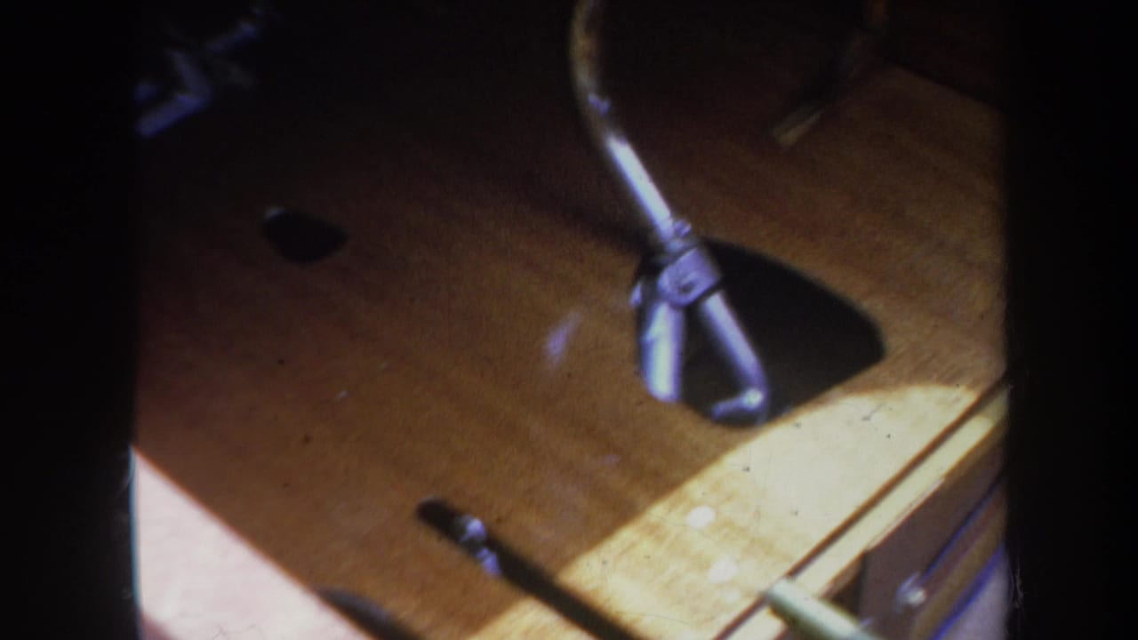 Close-up of a small model airplane part on a wooden surface with dark 8mm frame edges.