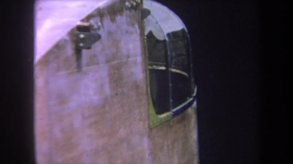 1969 home-movie frame showing the helicopter side profile, worn surface, and curved window framing.