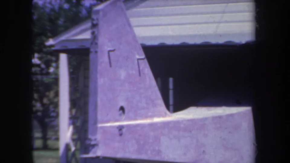 Purple home-built aircraft tail section seen beside a residential garage in Yucaipa, California, in 1969 footage.